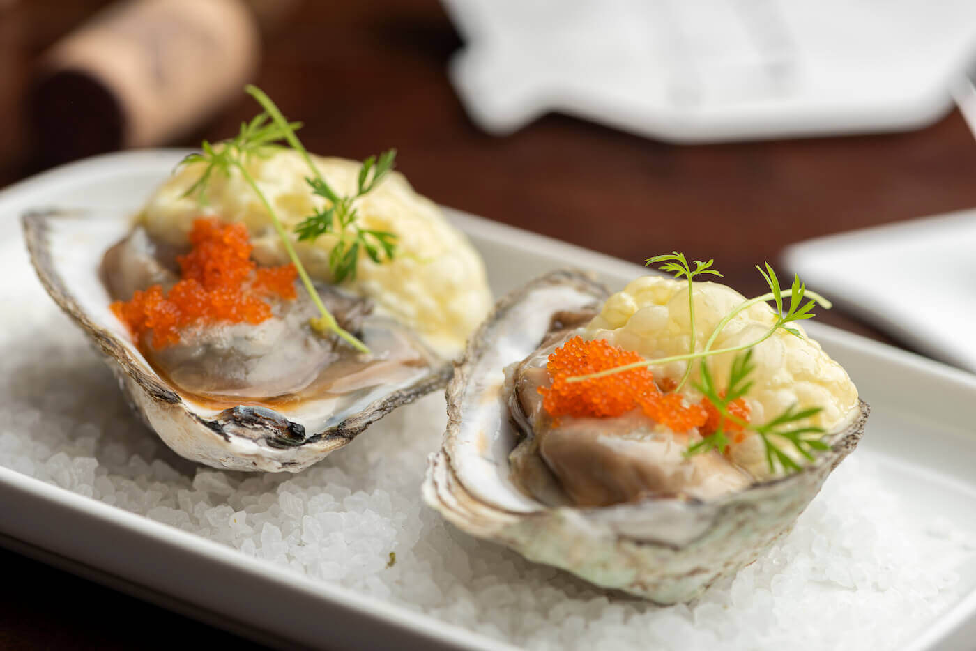 Oysters garnished with red caviar on salt and plate
