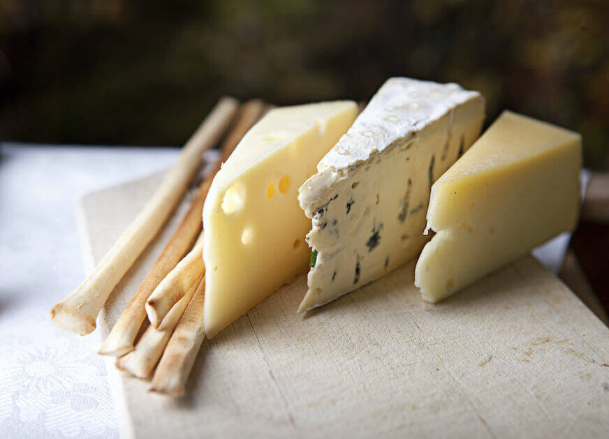 Three slices of cheese on a cutting board