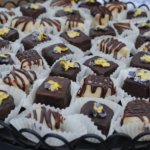 Small pastries sit arranged on a black tray