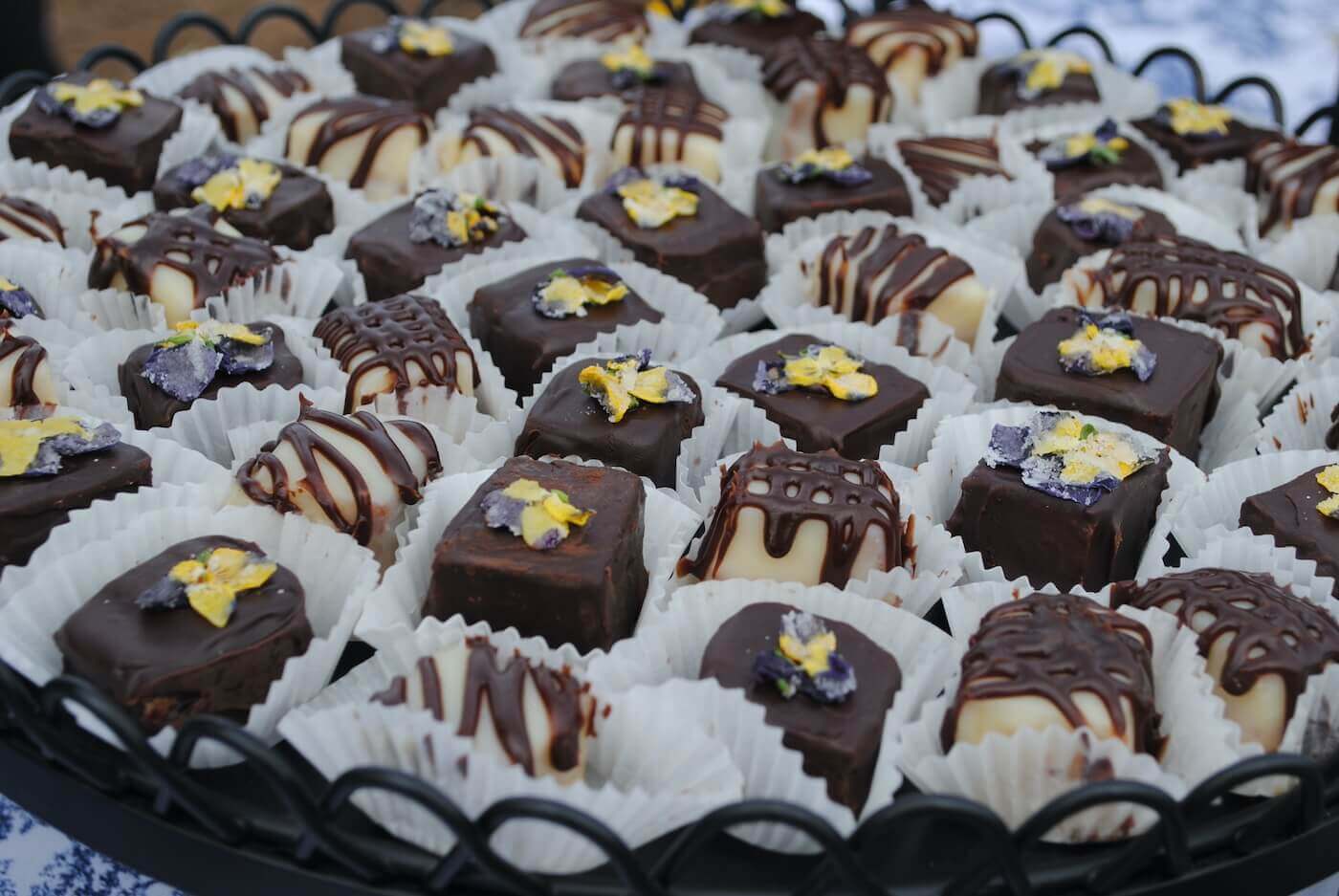 Small pastries sit arranged on a black tray