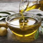 Olive oil being poured into glass bowl