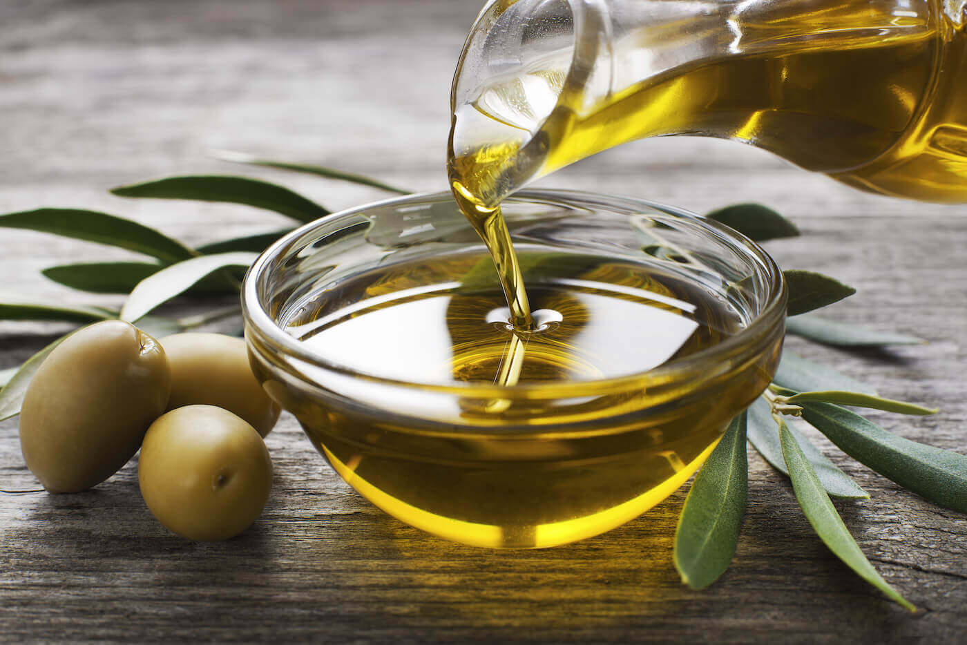 Olive oil being poured into glass bowl