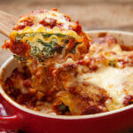 Baked lasagna with ricotta cheese in a red dish