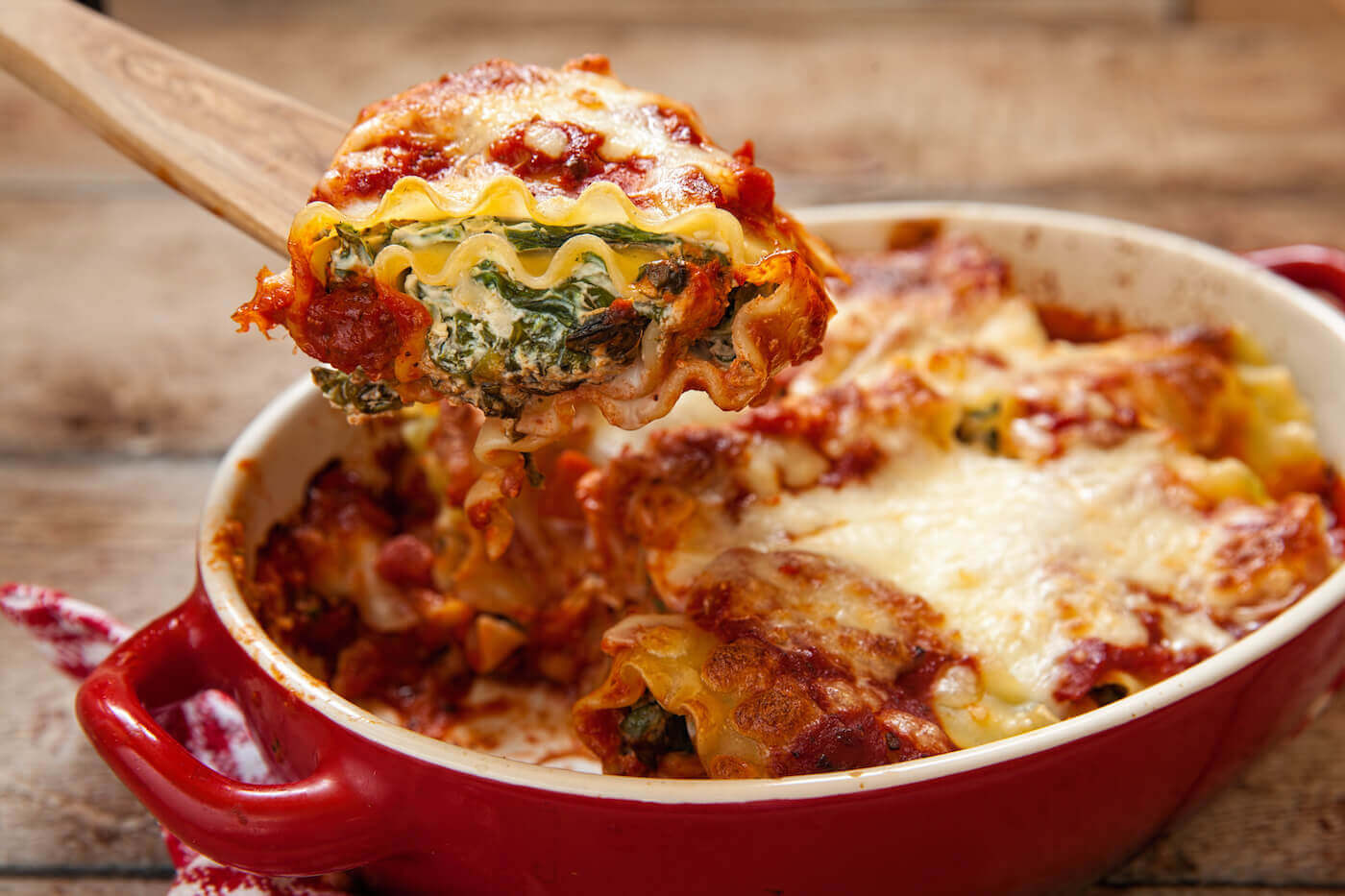 Baked lasagna with ricotta cheese in a red dish