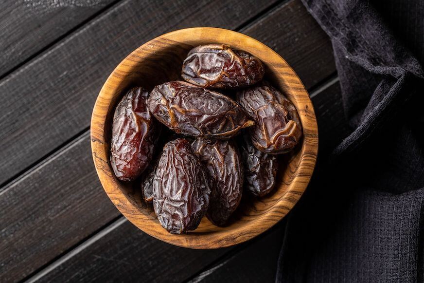 Dried dates in a wooden bowl