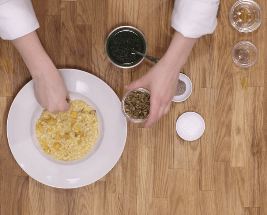 Chef adding seeds to a butternut Squash Risotto