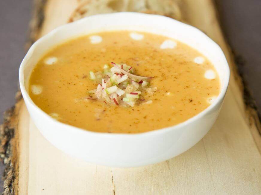 Sweet potapple soup in a white bowl