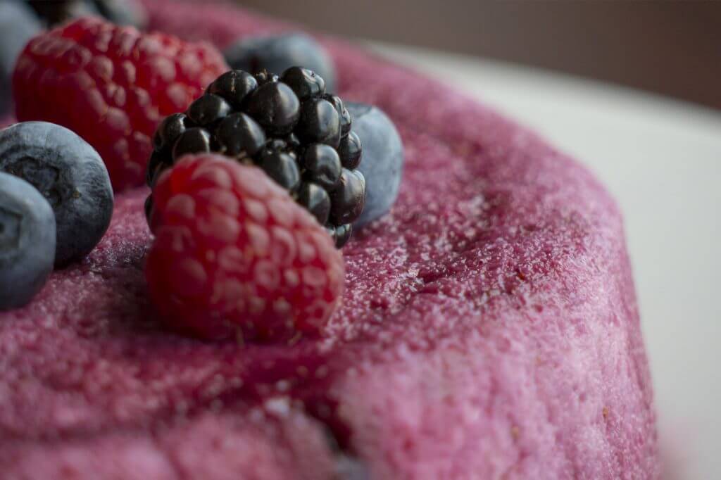 Garnish the cake with more berries, some whipped cream and mint leaves.