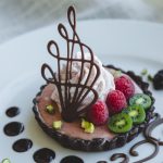 Garnish the chocolate cherry tart with whipped cream, fresh fruit and chocolate candies.