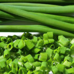 Image of chives finely diced, with chive shoots in the background