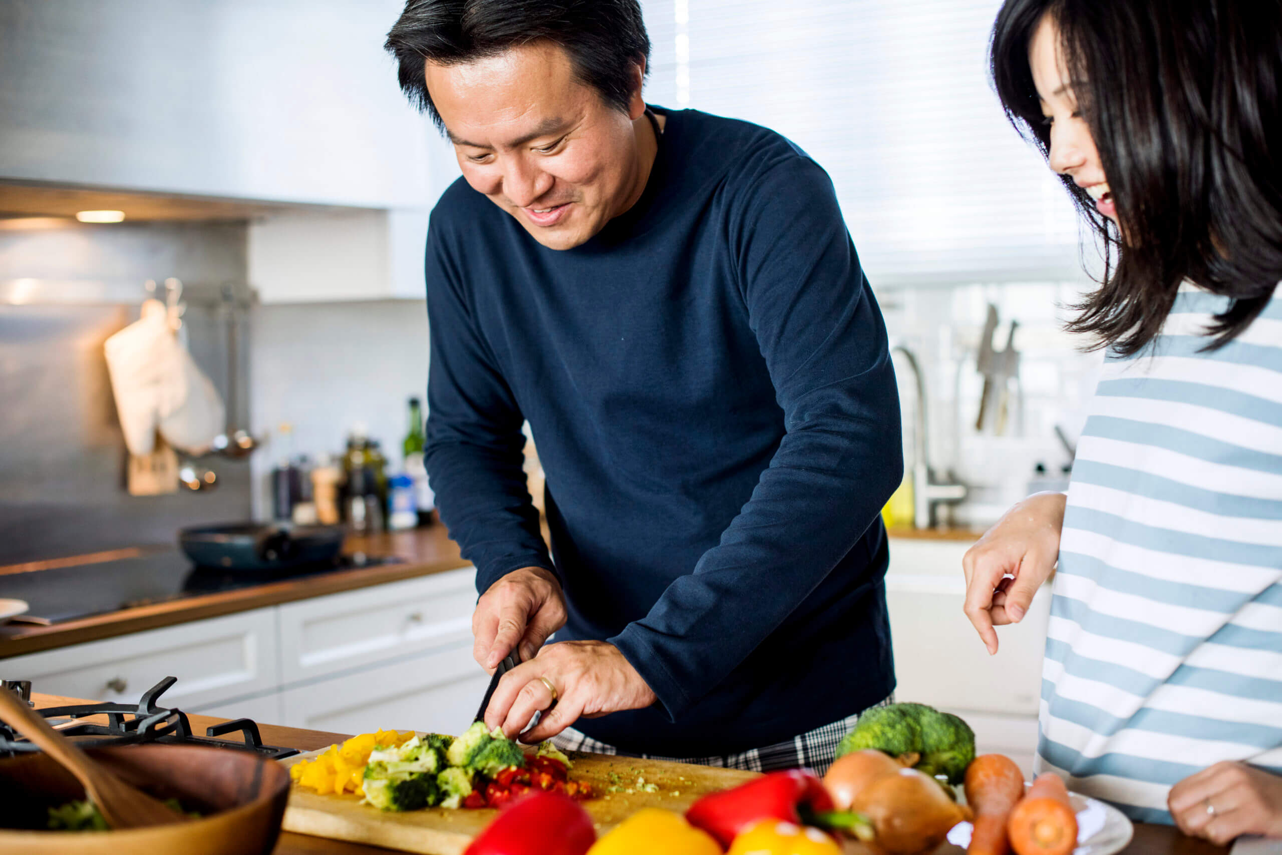 Couple chopping vegetables in the kitchen