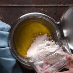 Preparation of veloute sauce on the wooden table