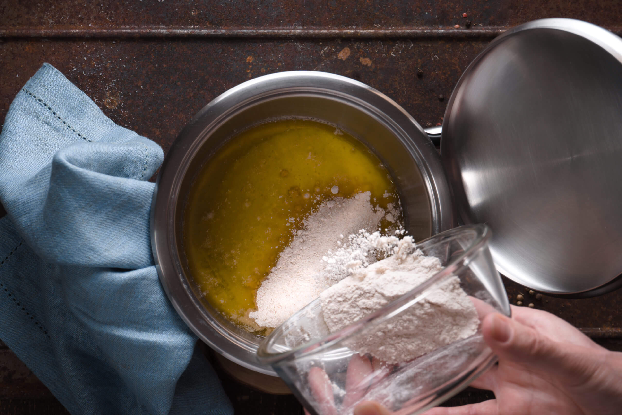 Preparation of veloute sauce on the wooden table