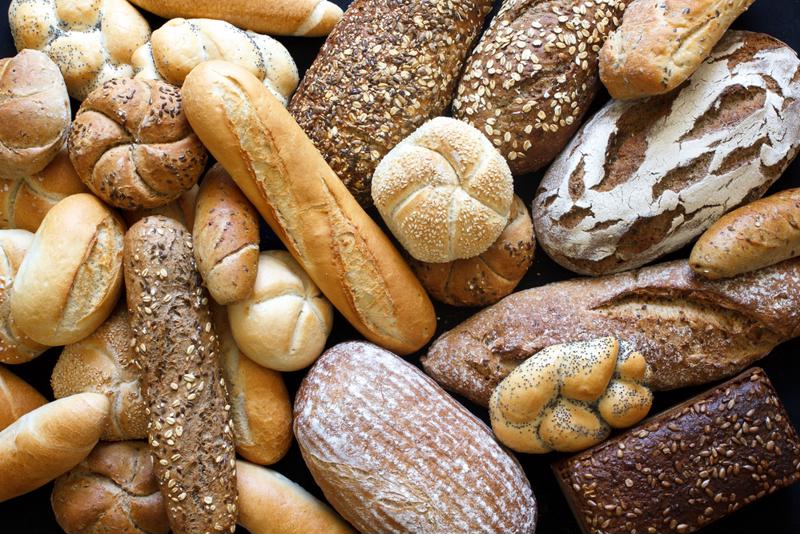 Different kinds of bread loaves in a pile.